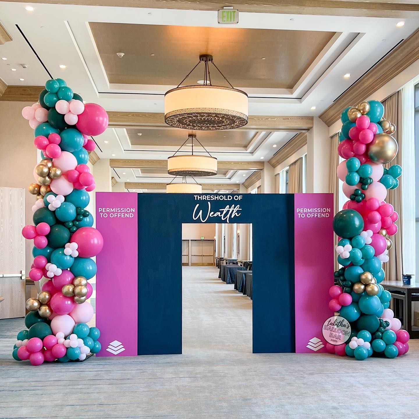 A room filled with balloons and a sign that says wealth