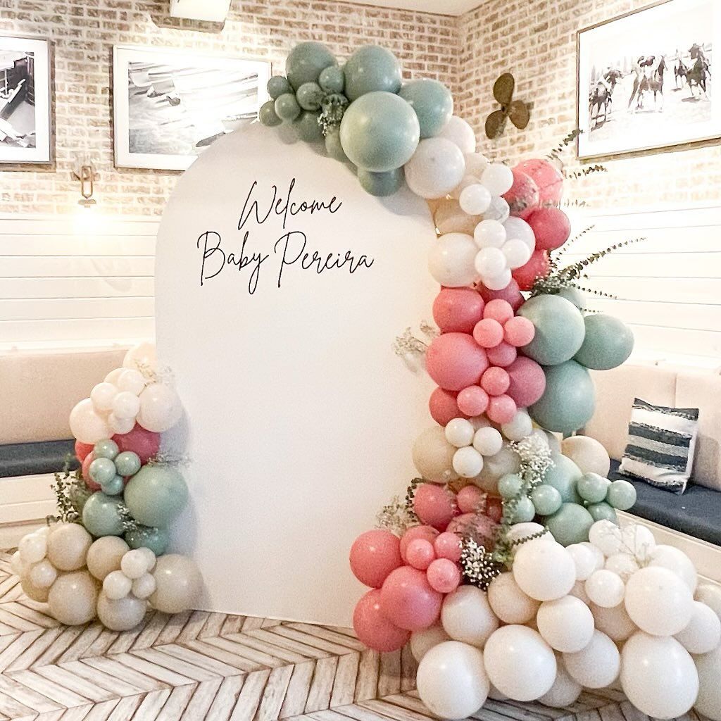 A room decorated with balloons and flowers for a baby shower.