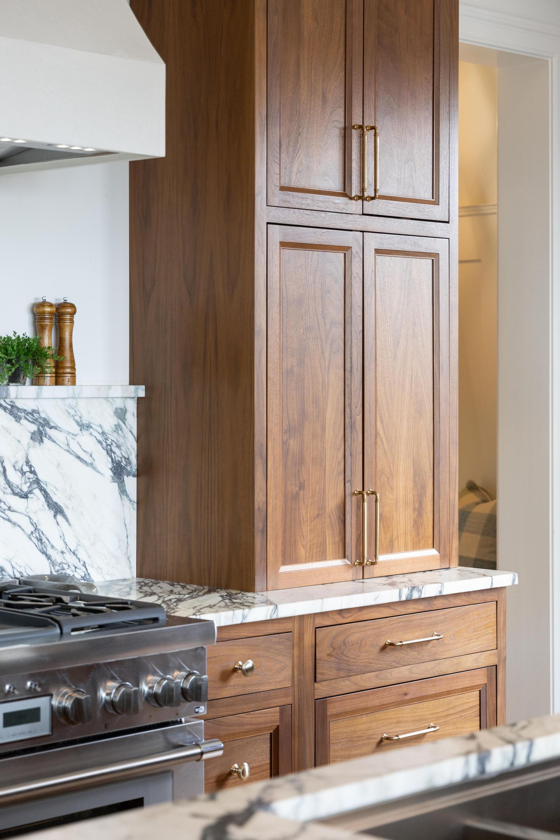 Kitchen with wooden cabinets, marble countertops, and a stainless steel stove.