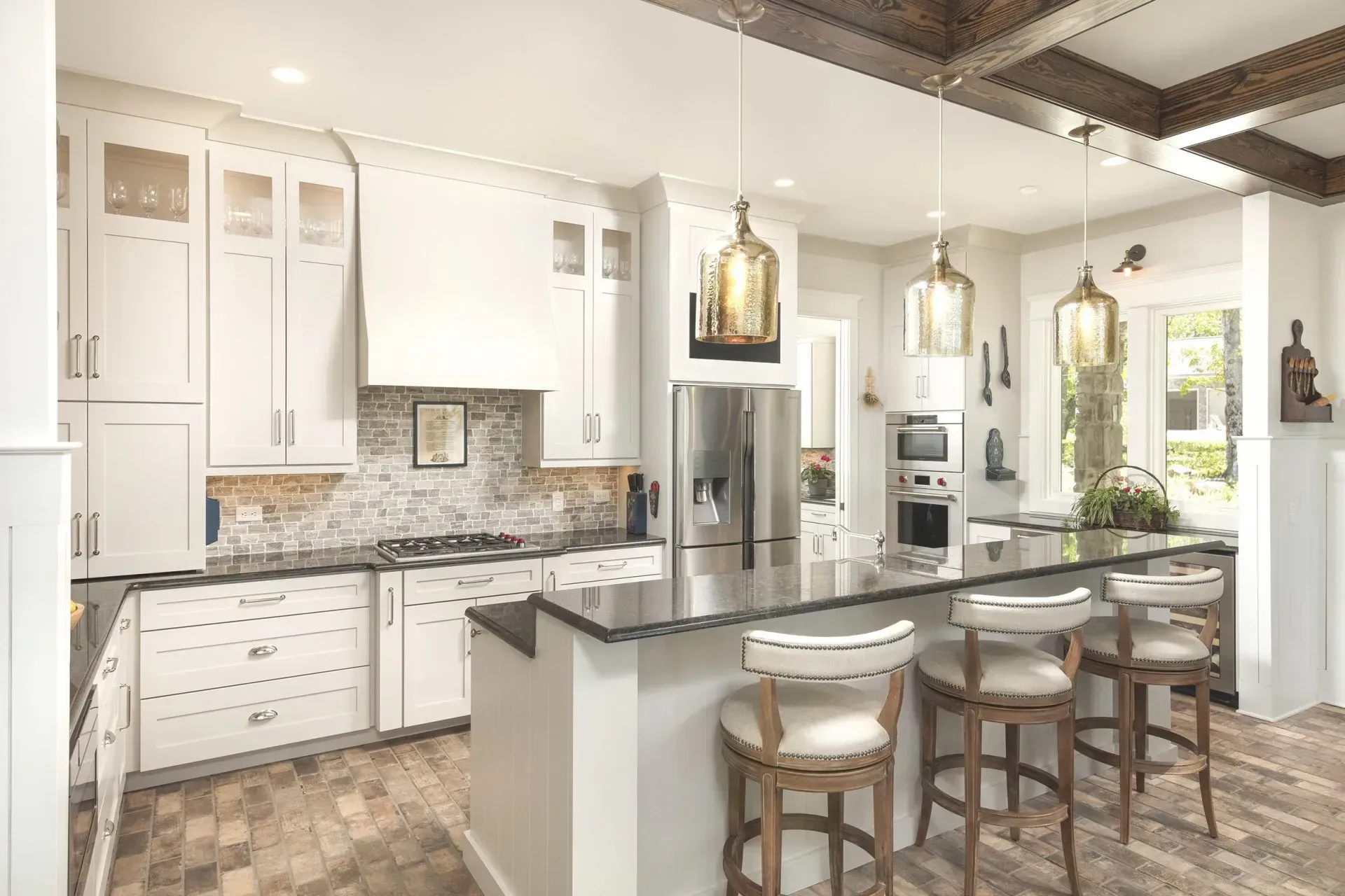 Bright white kitchen with a dark countertop island and matching bar stools.