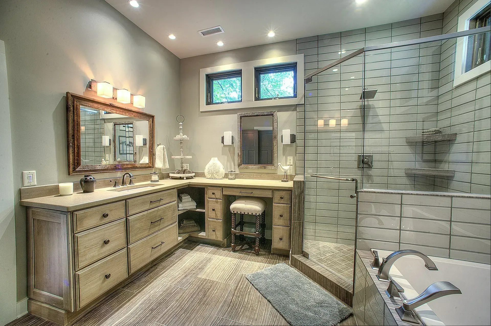 Bathroom with wooden vanity, glass shower, and tiled walls.