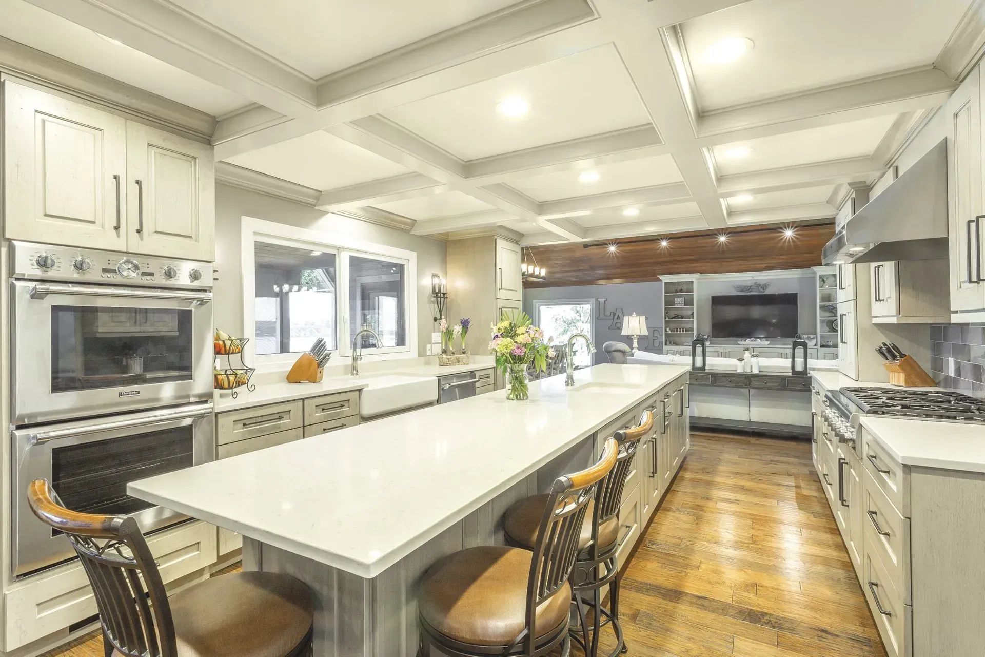 Spacious kitchen with large island, stainless steel appliances, and wood flooring.