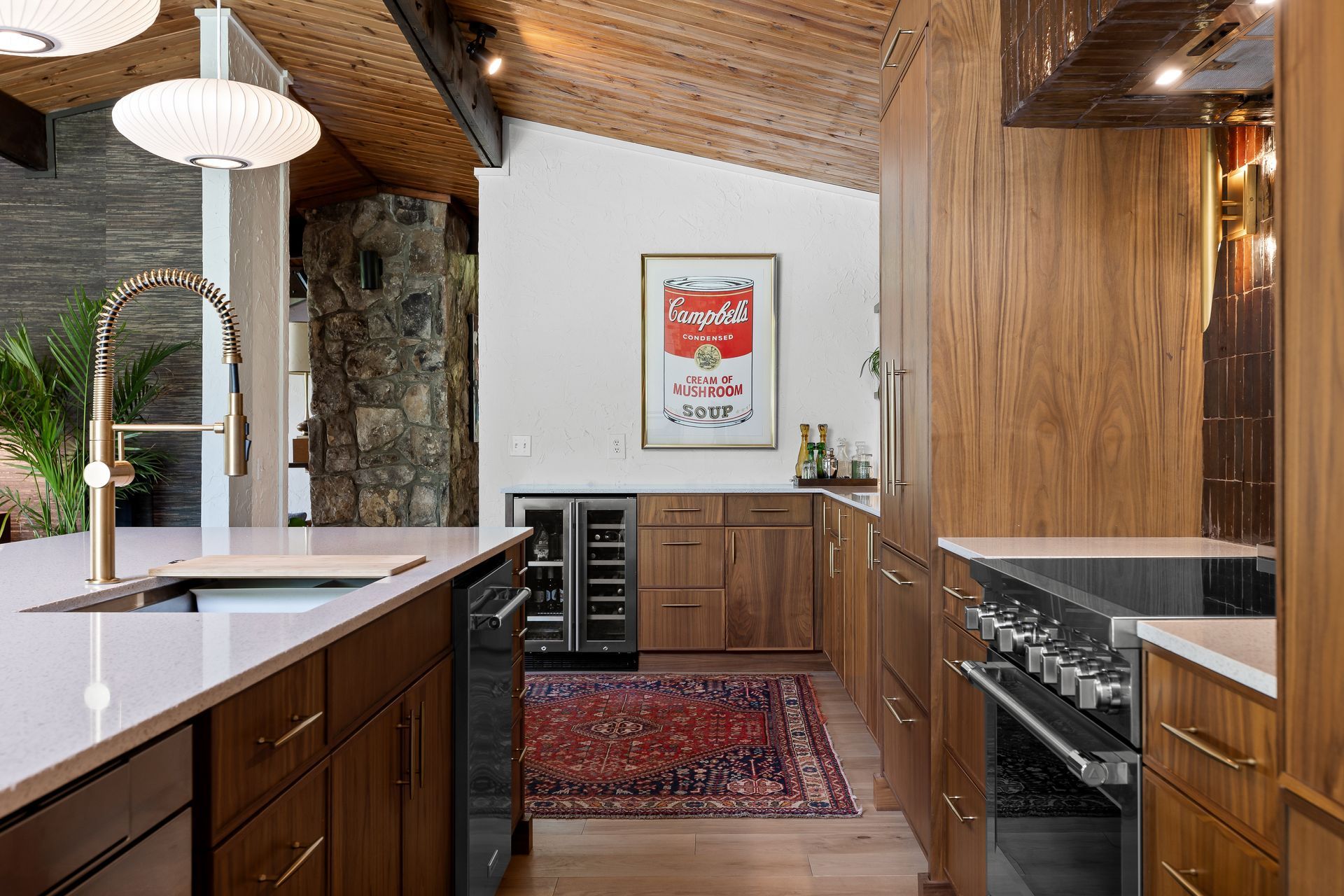 Modern kitchen with wood cabinets, island, and Campbell's Soup art.