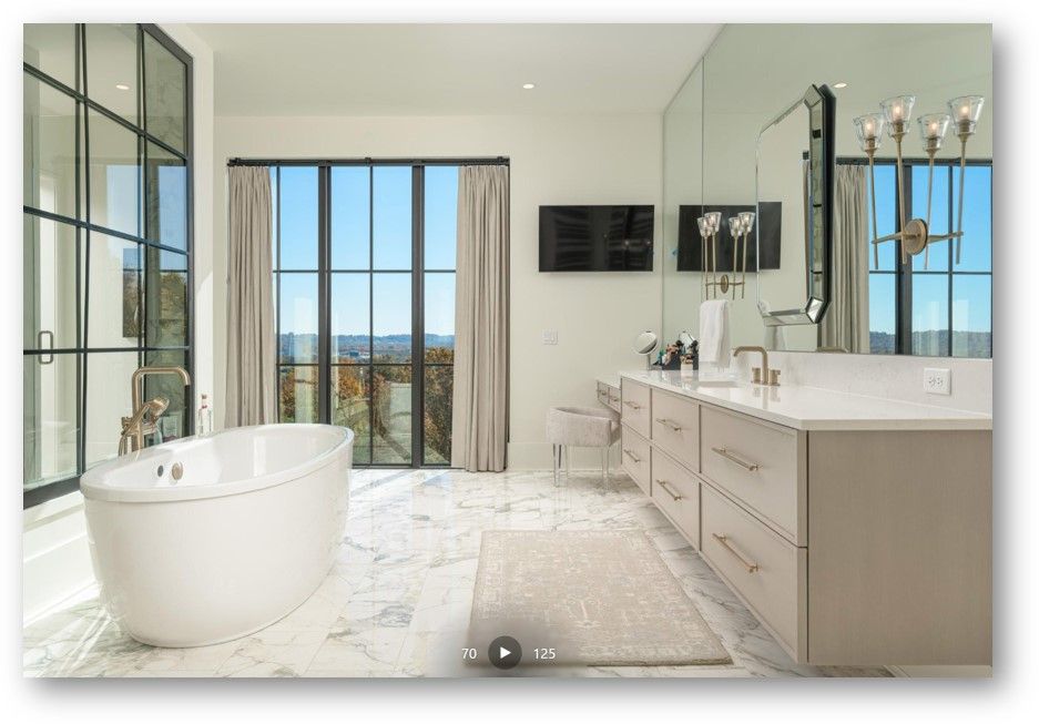 Luxurious bathroom with soaking tub, large window, and double vanity.