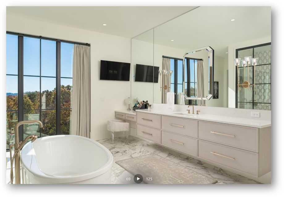 Modern luxury bathroom with a bathtub, large windows, and a vanity.