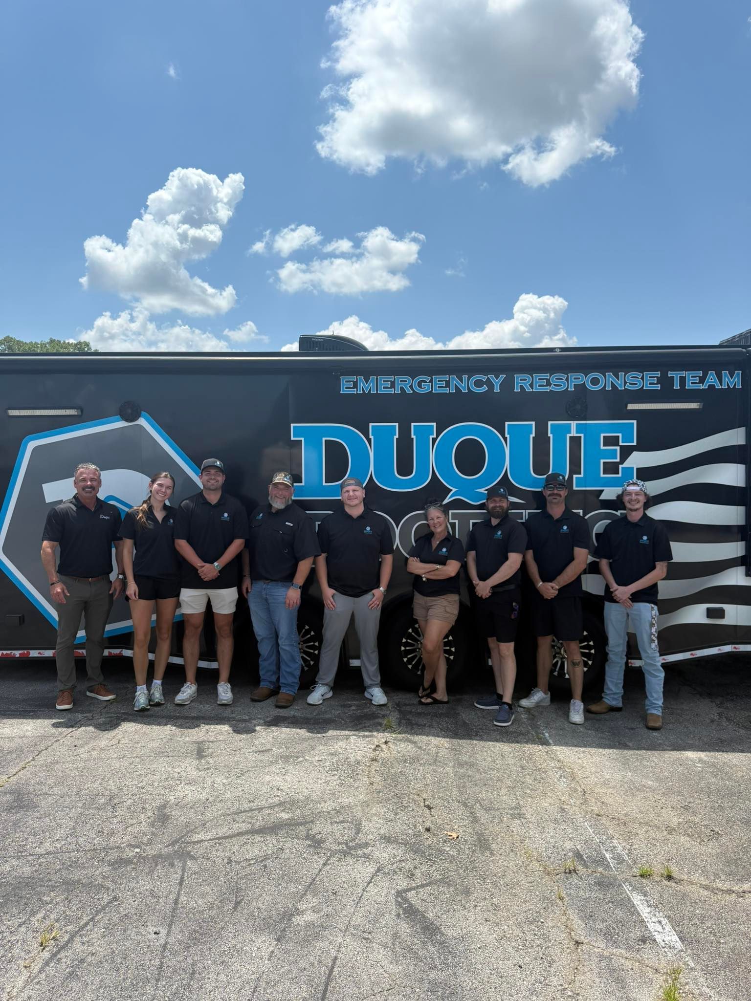 Group of people in matching shirts in front of a trailer that reads 