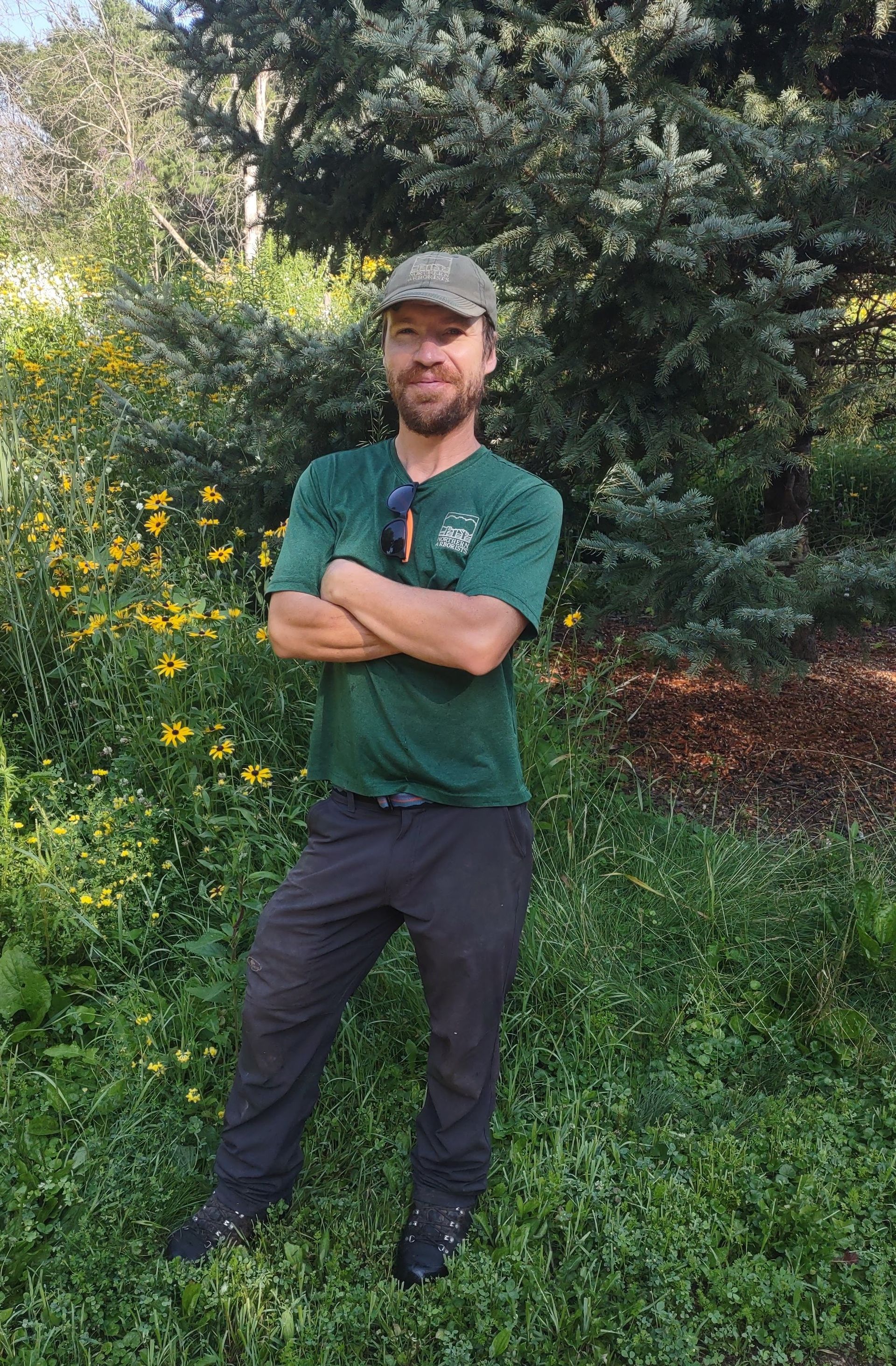 A man with a beard with crossed arms.