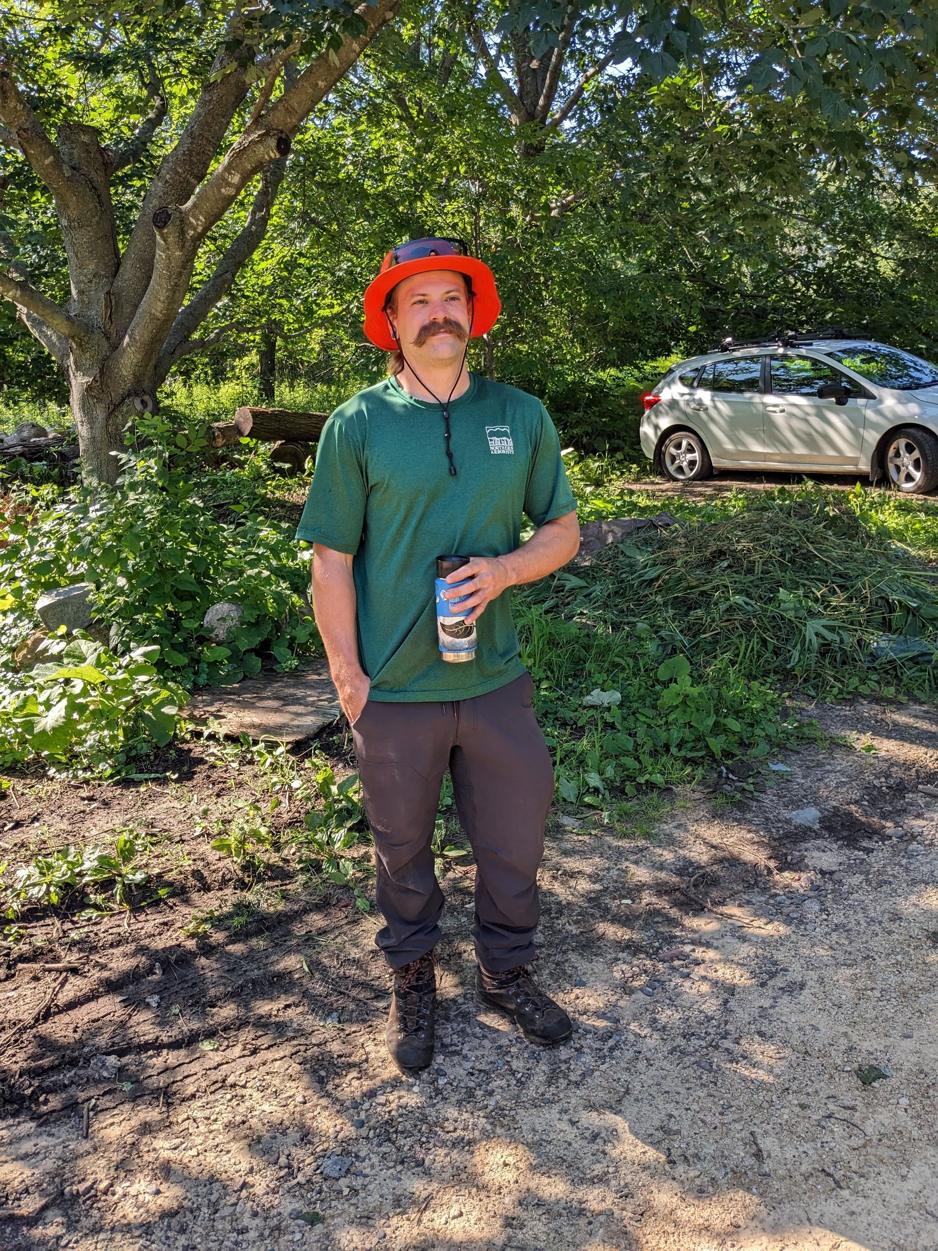 A man with a beard wearing a green shirt and a red hat