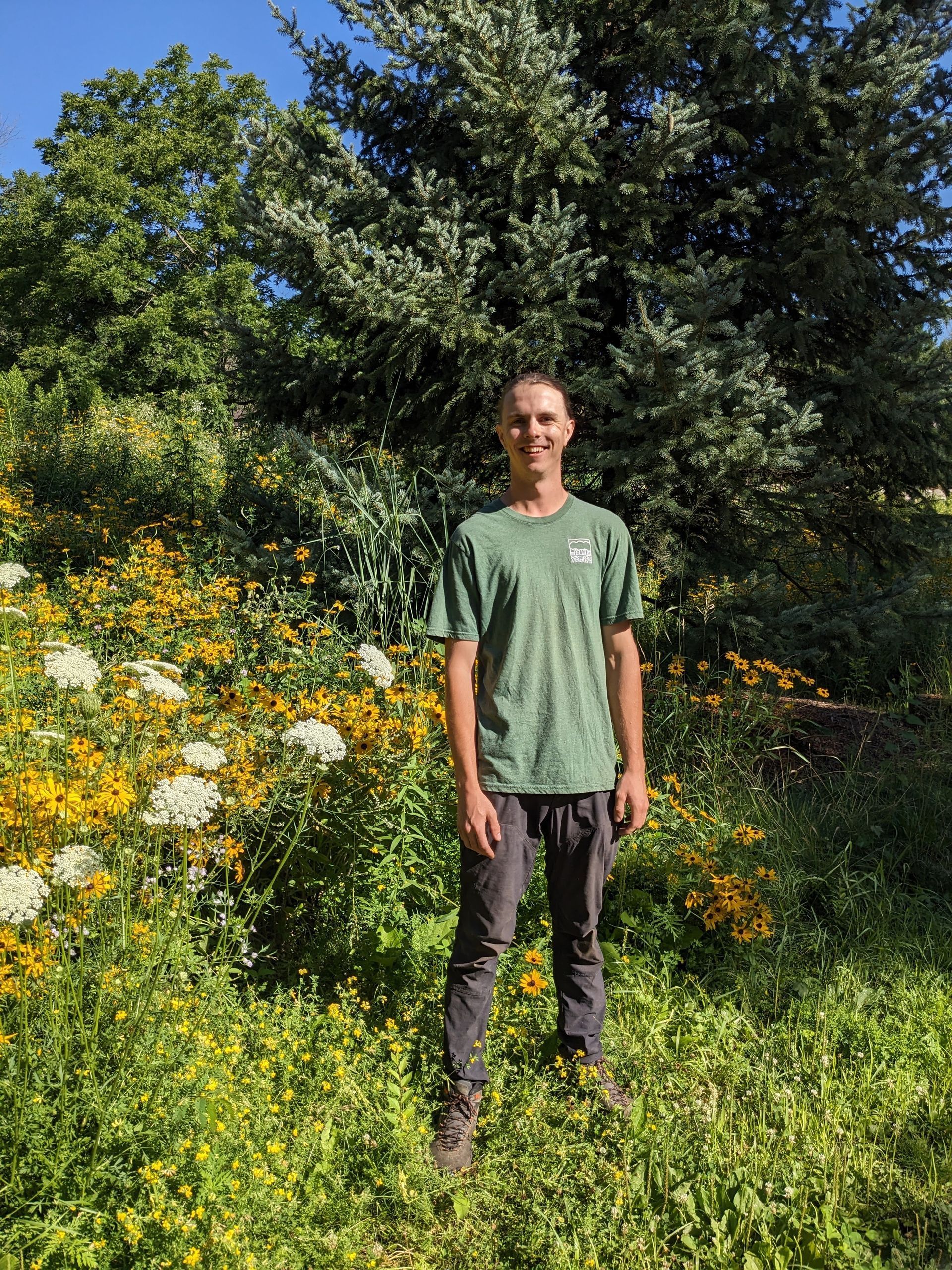 Handsome arborist stands in beautiful prairie.