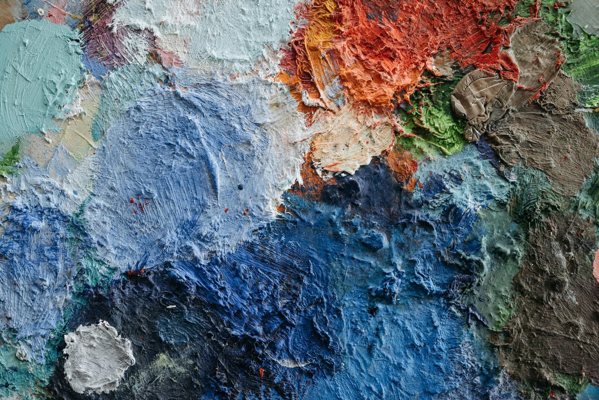 Abstract, gestructureerd schilderij in blauwe, witte, rode en groene tinten.
