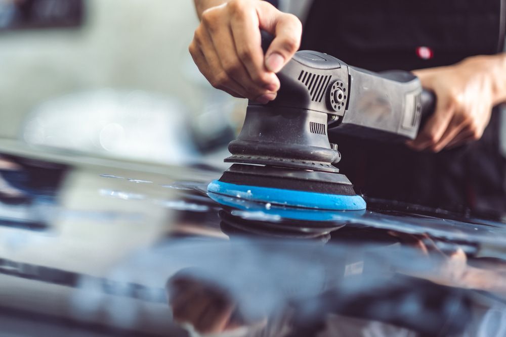 A Man is Polishing a Car With a Machine — Stengels Crash Repairs In Garbutt, QLD