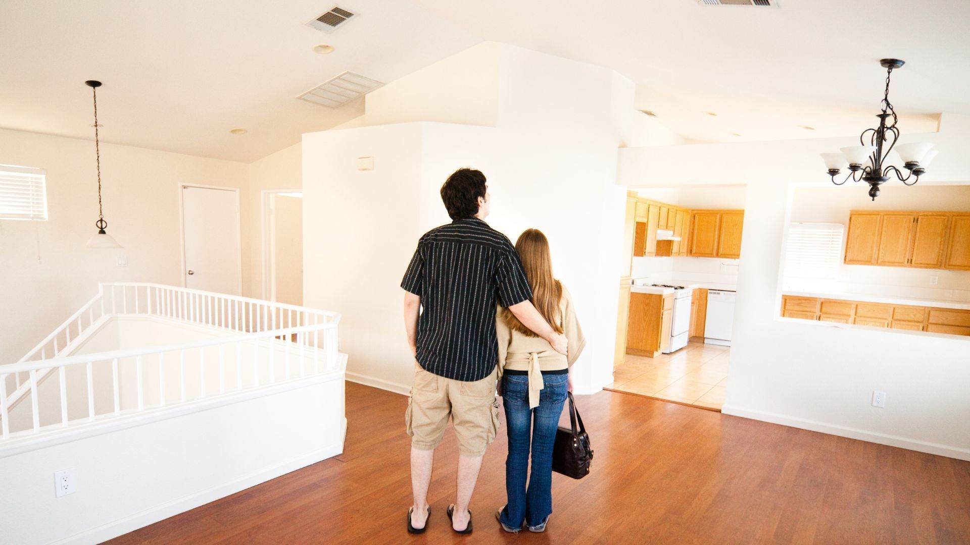 A man and a woman are looking at an empty house.