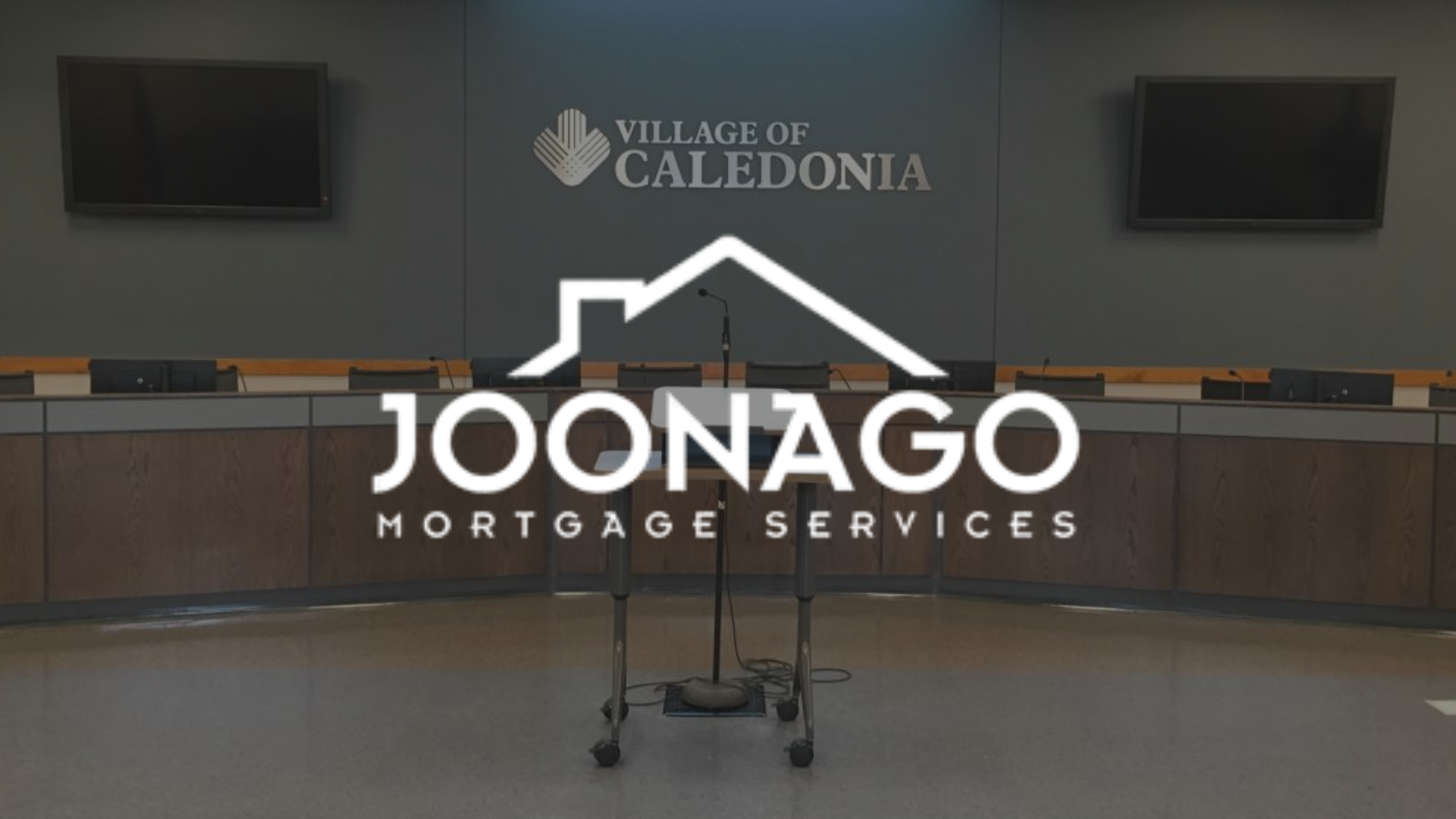 Empty stage in Caledonia village hall with Joonago Mortgage Services logo overlaid.