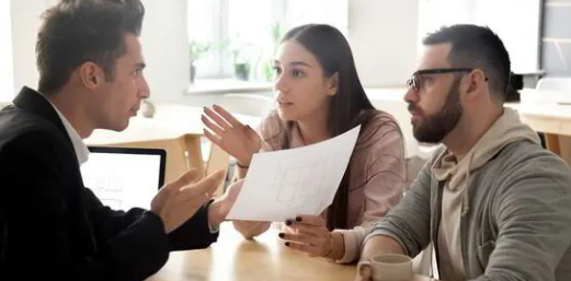 A man is talking to a woman and a man while holding a piece of paper.