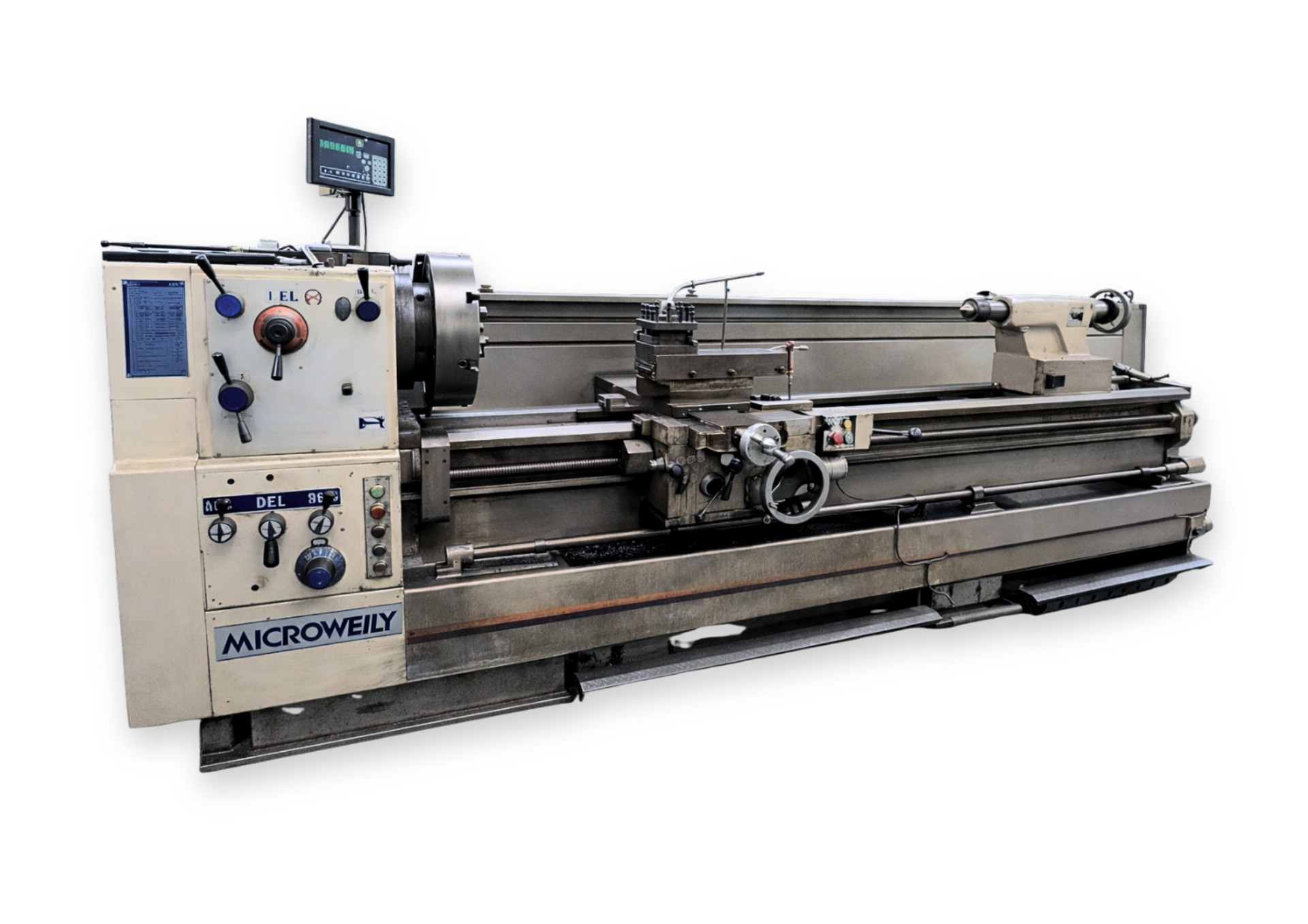 Large gray industrial lathe machine in a workshop, with control panel and windows in the background