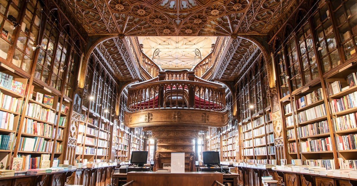 Grand library with ornate woodwork, filled with bookshelves and a central balcony.