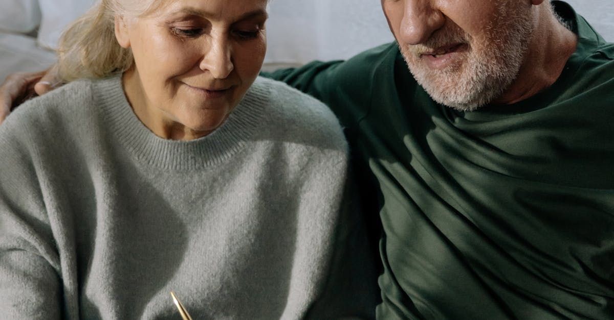 Couple looking at something together. The woman is wearing a light green sweater, the man a green shirt.
