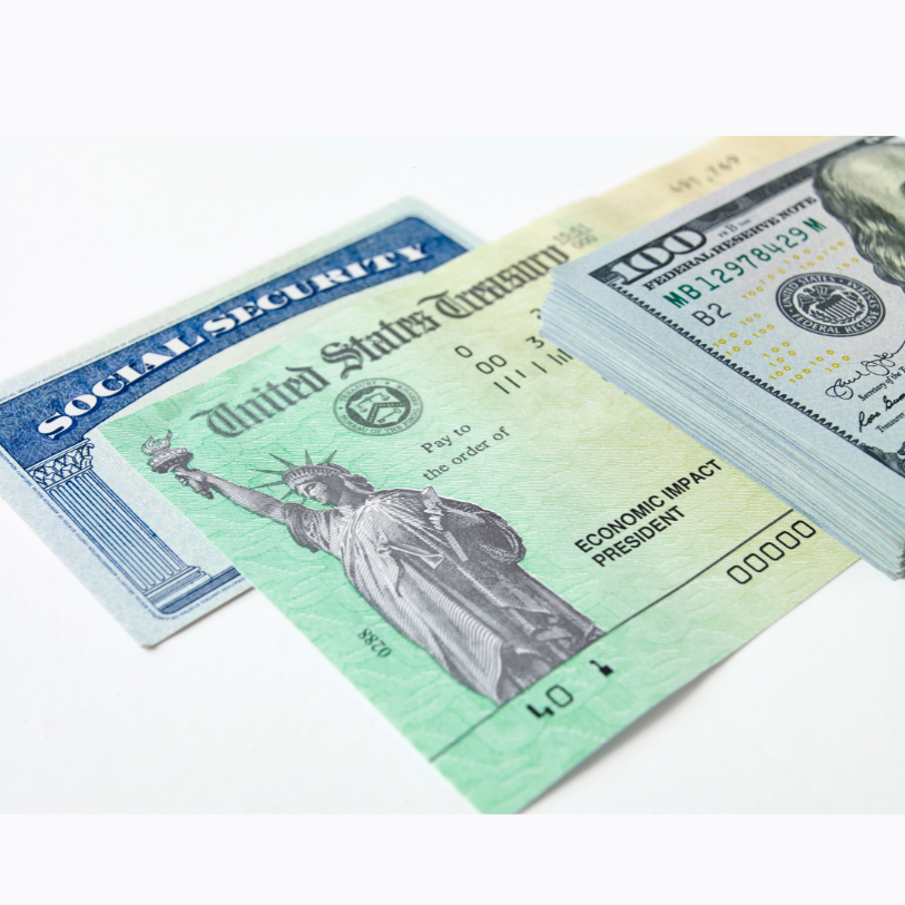 Social Security card, U.S. Treasury check, and a stack of $100 bills on a white surface.