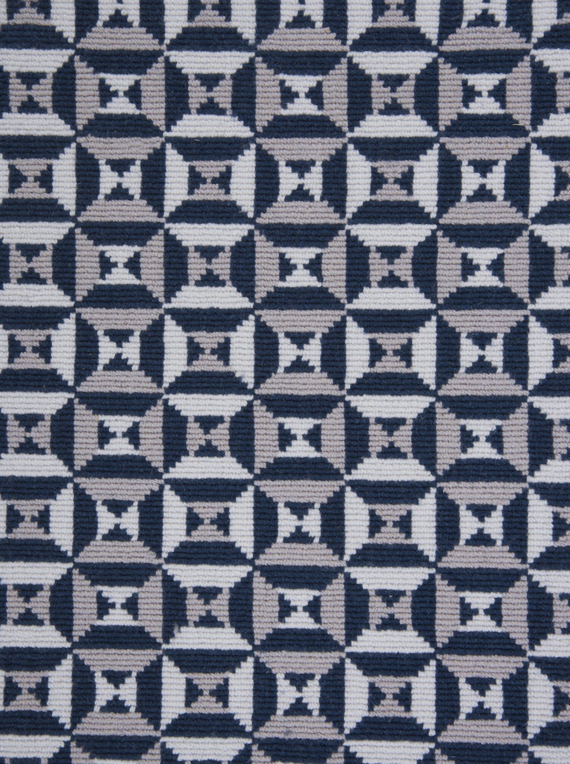 Geometric textile pattern in navy, gray, and white square and circle shapes.
