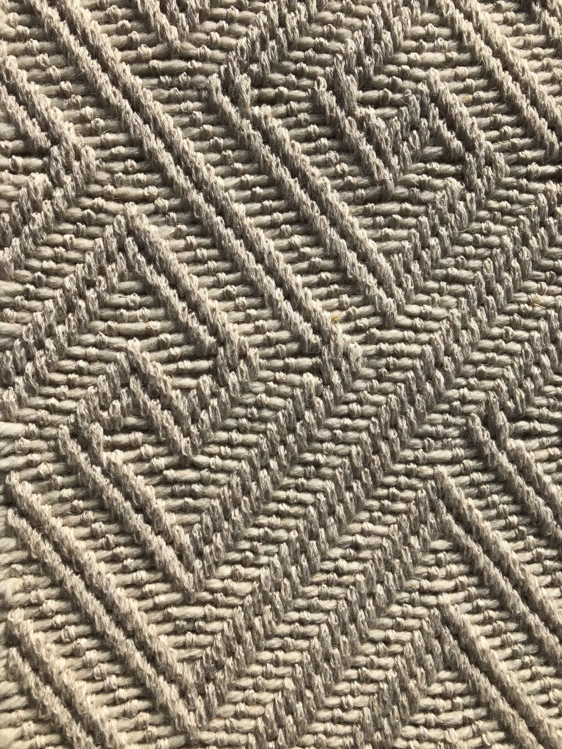 Beige textured fabric with diagonal and zigzag patterns.