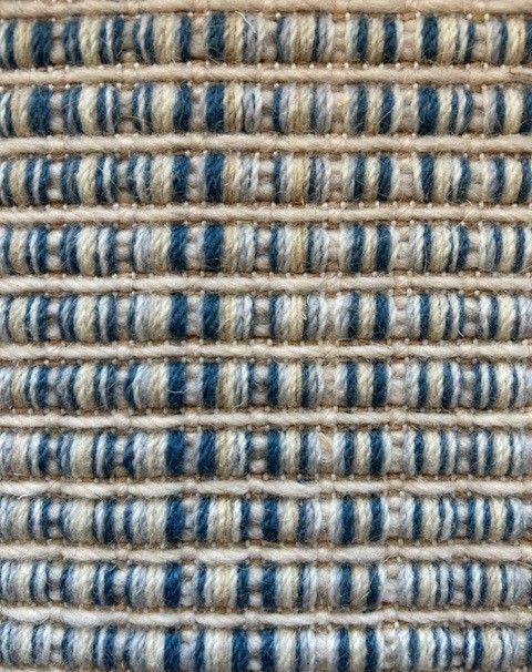 Textured carpet with alternating blue and beige horizontal stripes.