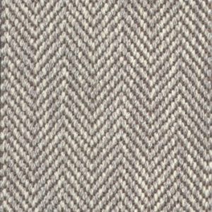 Close-up of a carpet with a light brown and beige herringbone pattern.