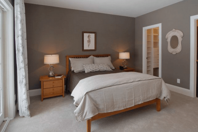 Bedroom with a bed, nightstands, lamps, and a walk-in closet. Walls are gray.