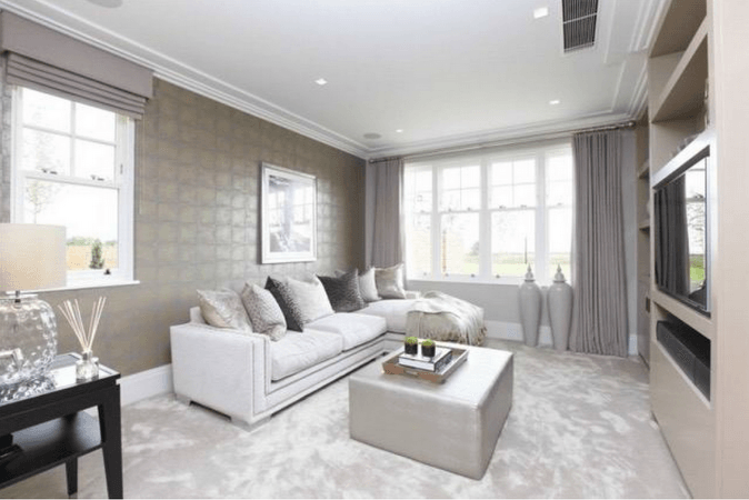 Bright, open-plan living room with white walls, large windows, and a modern kitchen.