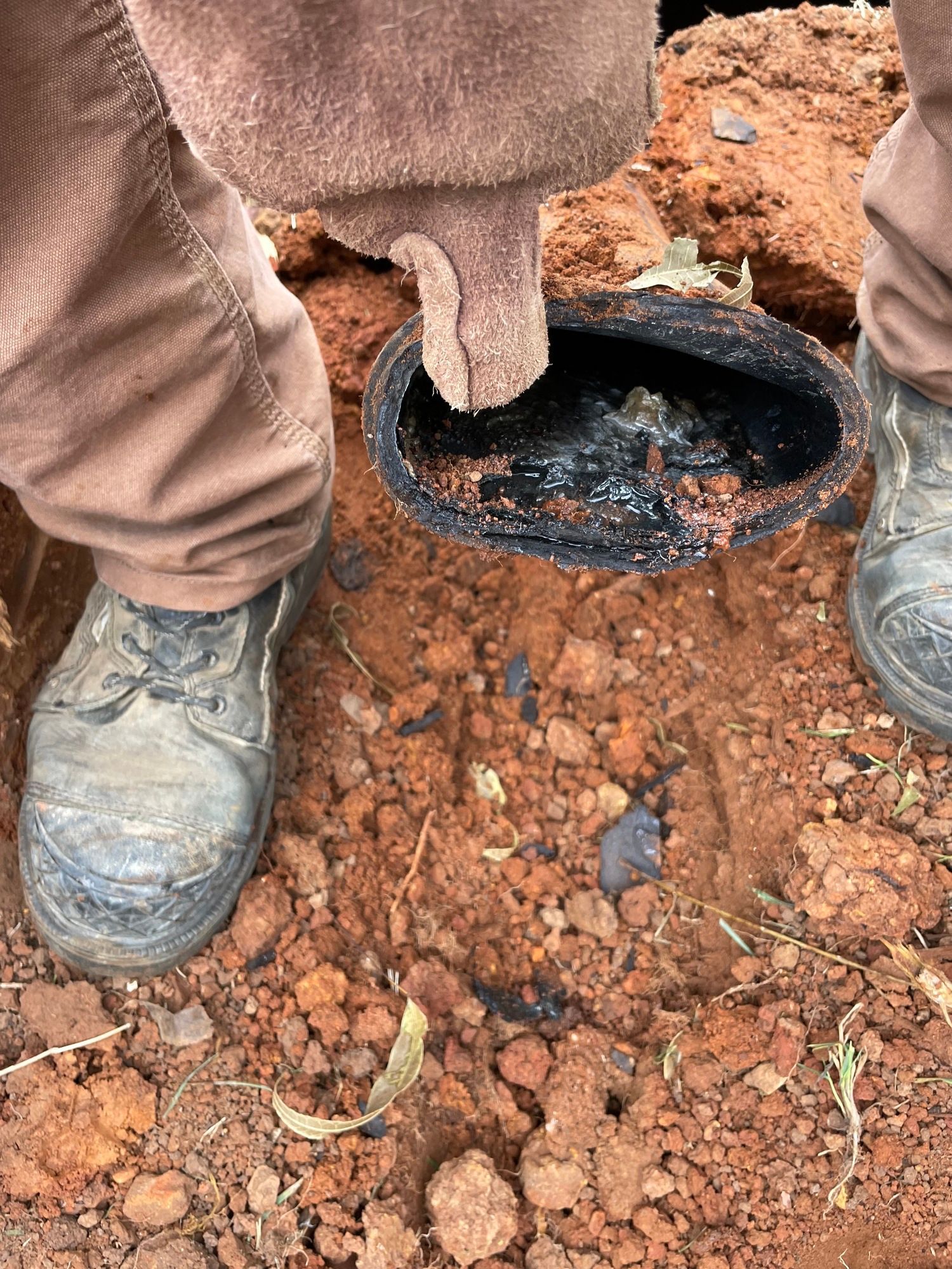 A person is standing next to a hole in the ground.