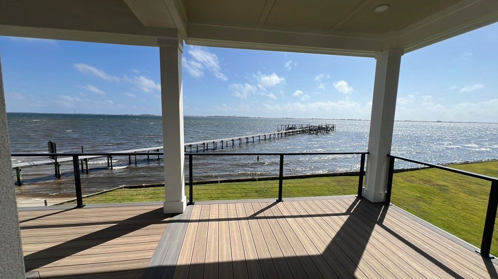 A deck with a view of the ocean and a pier.