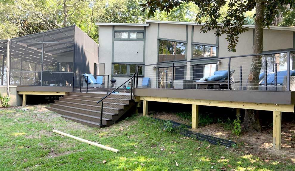 A house with a large deck and stairs in front of it.