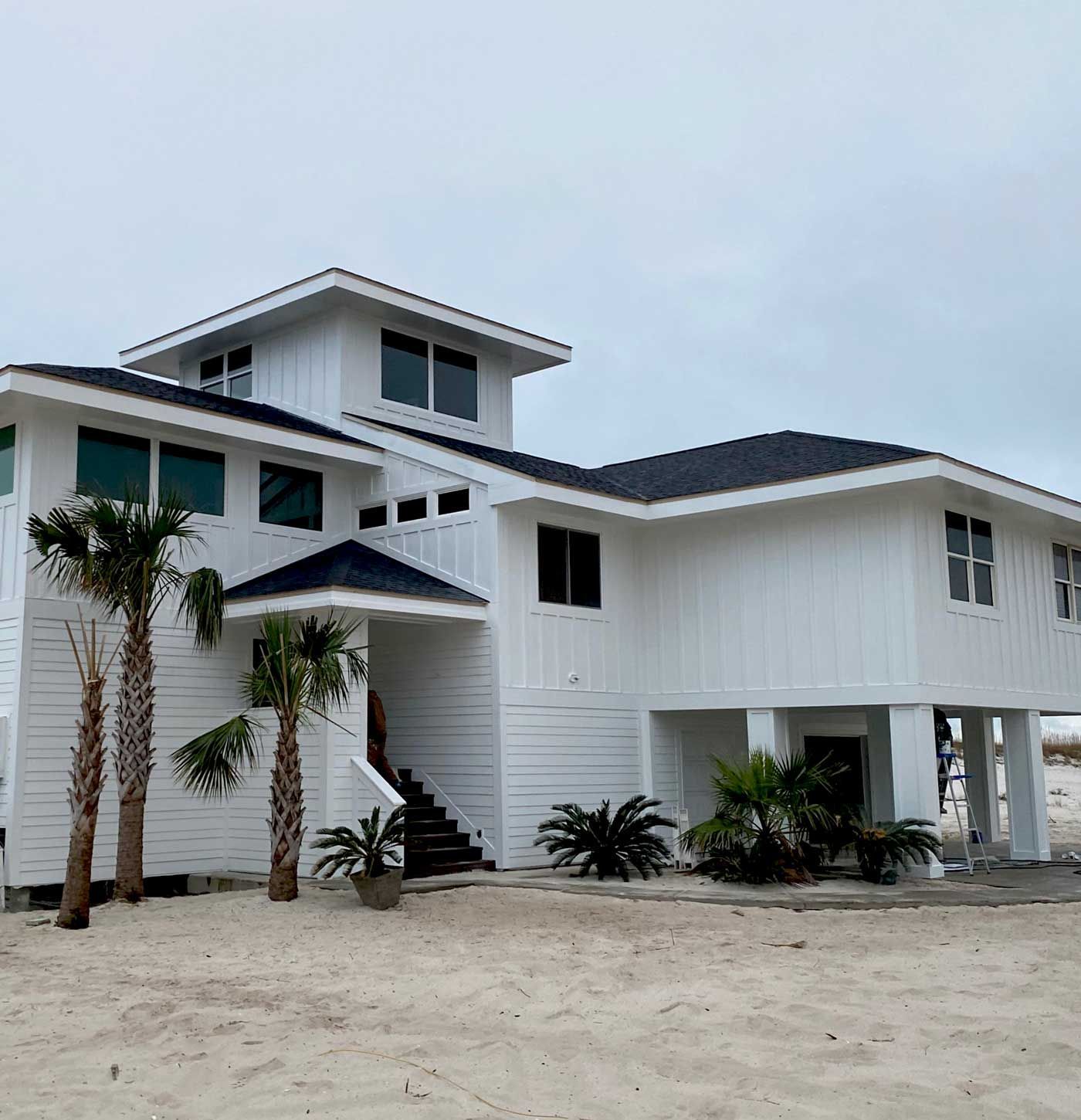 A large white house with palm trees in front of it.