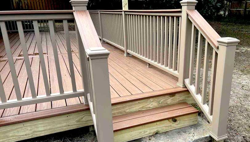 A wooden deck with stairs and railing.