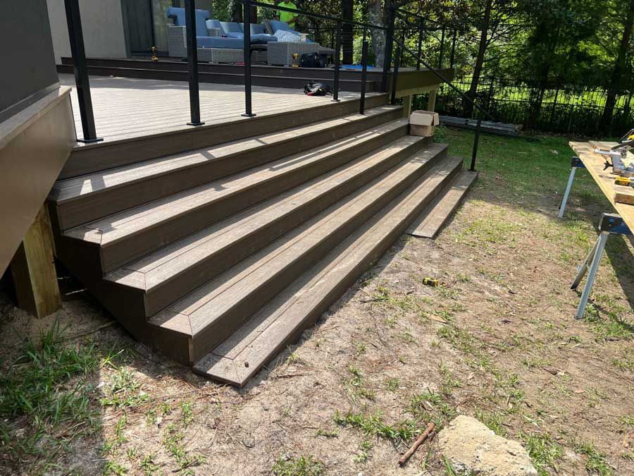 A wooden deck with stairs leading up to it is being built.