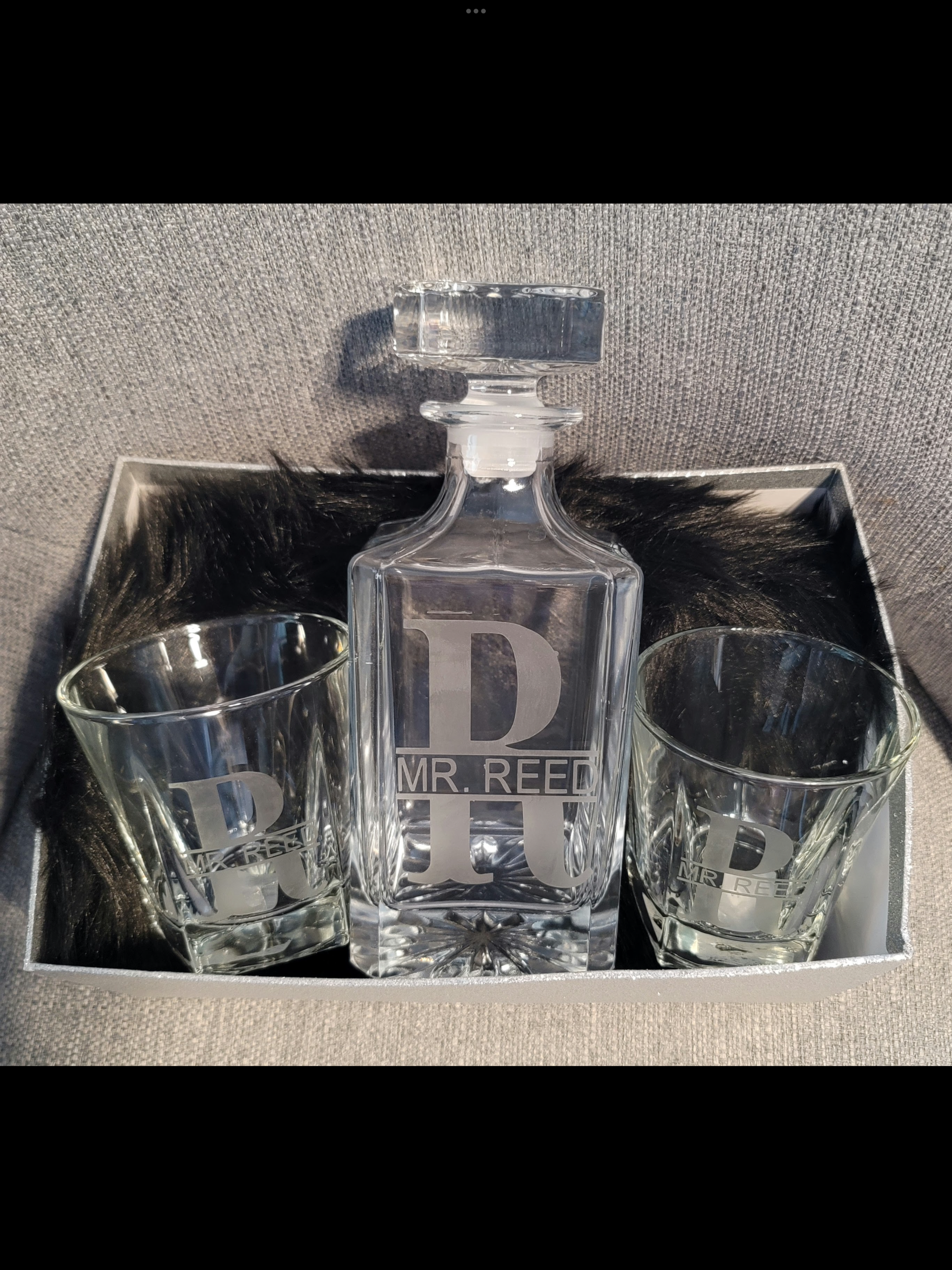 A decanter and two shot glasses with the name k. warren on them