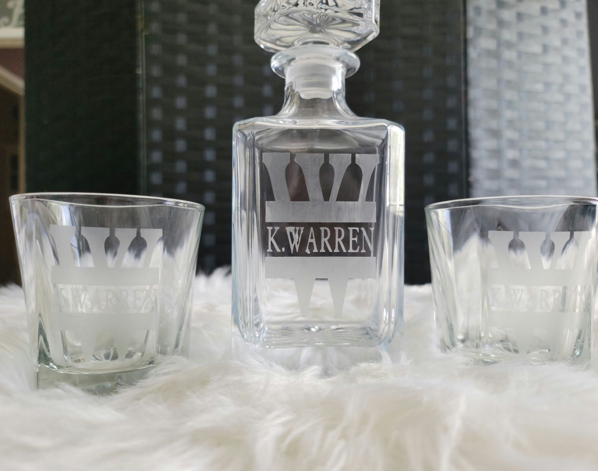 A decanter and two shot glasses with the name k. warren on them