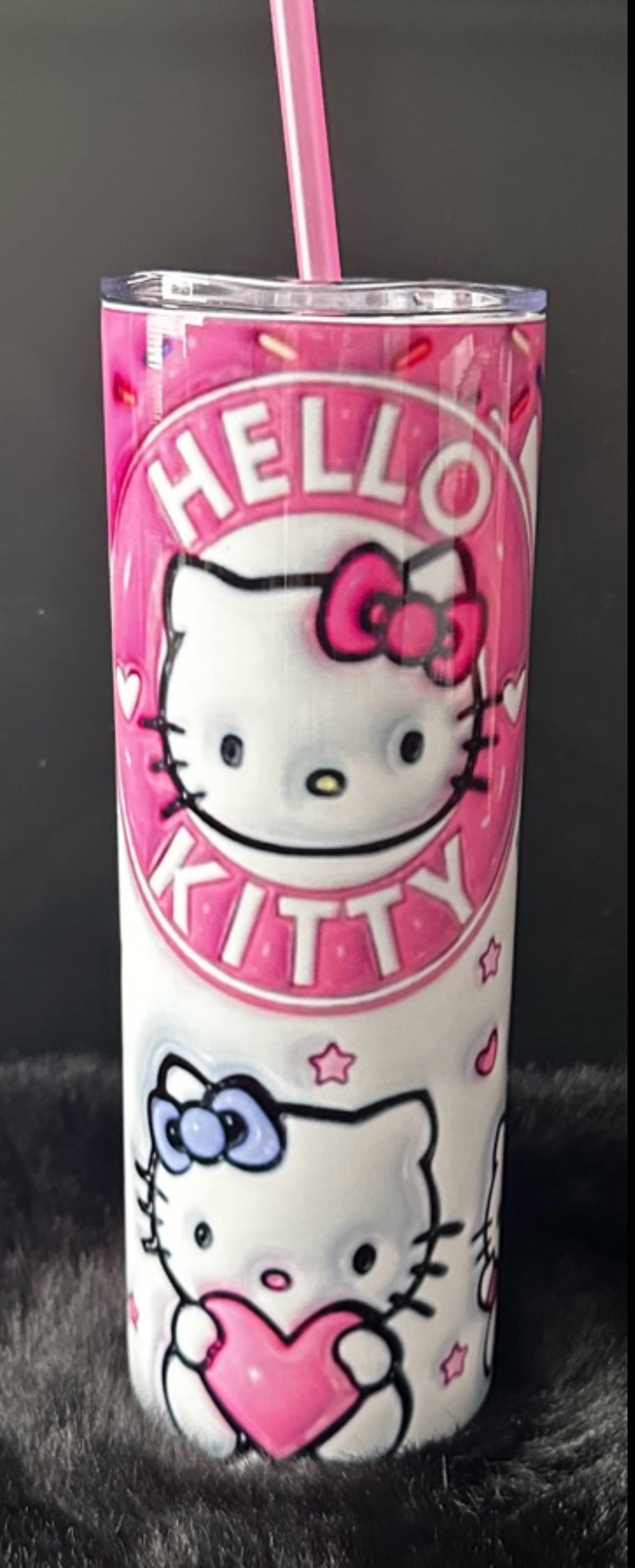 A hello kitty tumbler with a pink straw.