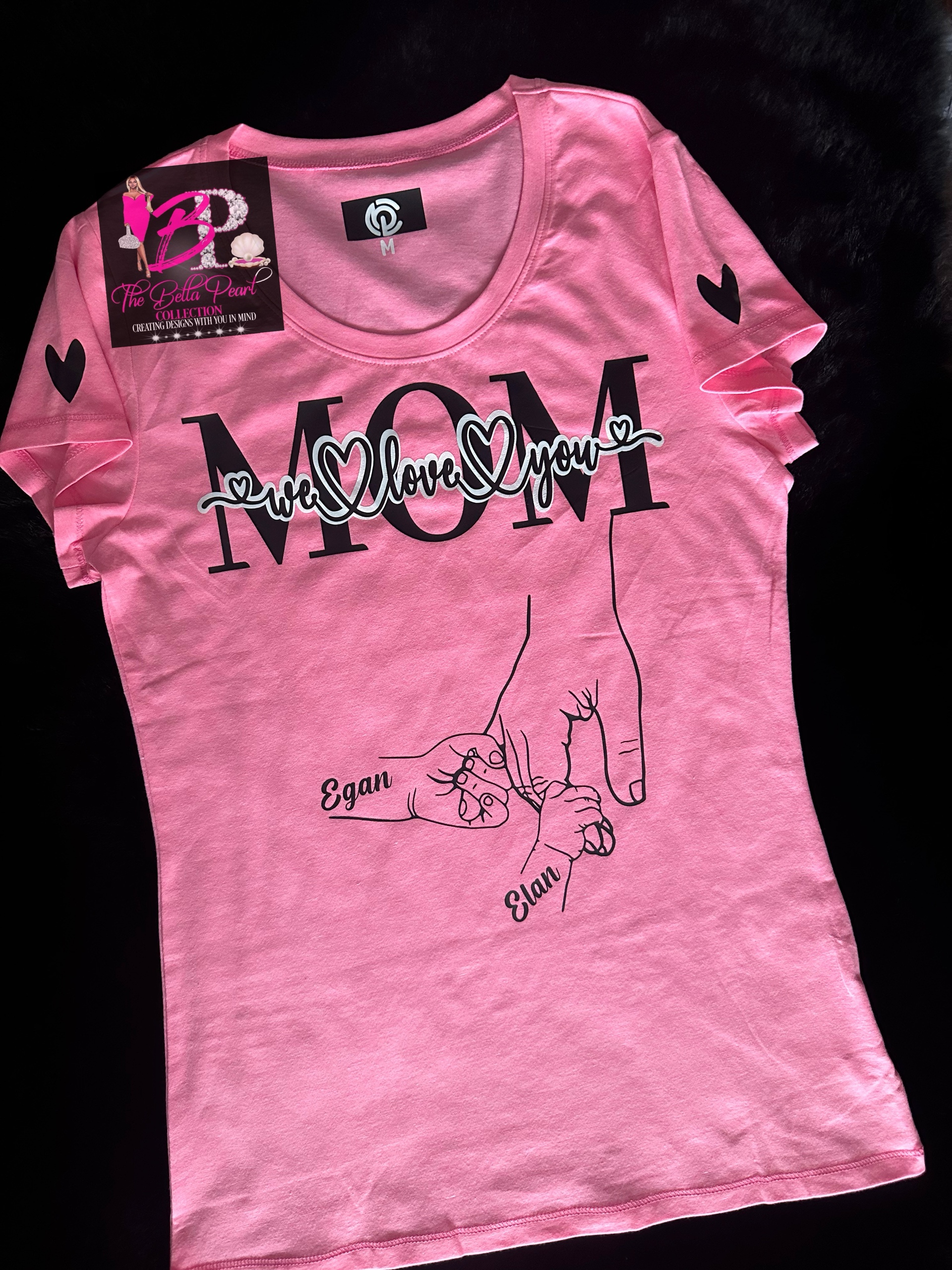 A pink t-shirt with the word mom on it with children holding her hand. Personalized