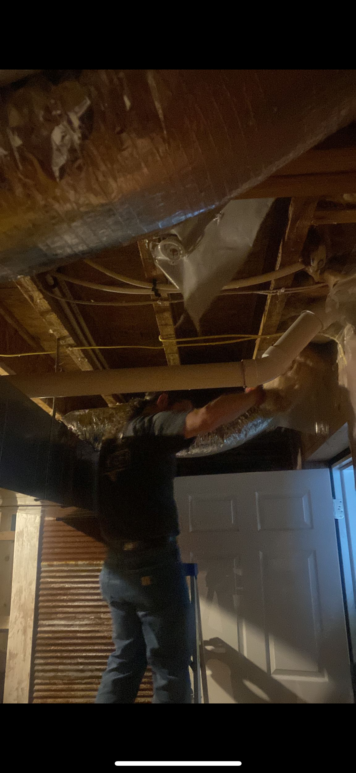 A man is installing a filter on the ceiling of a room.