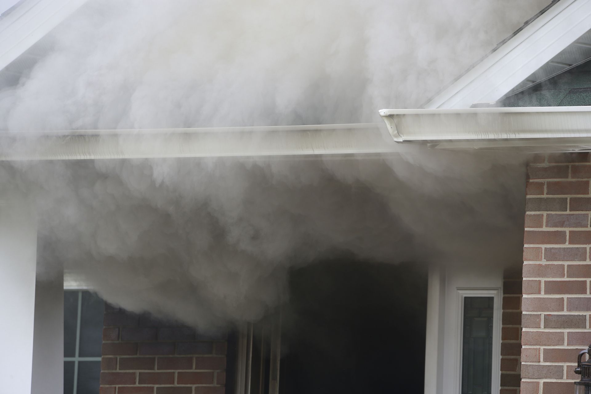 Smoke is coming out of the roof of a house.