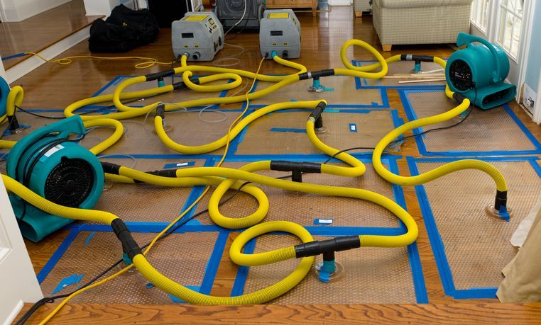 A bunch of yellow hoses are laying on the floor in a room.