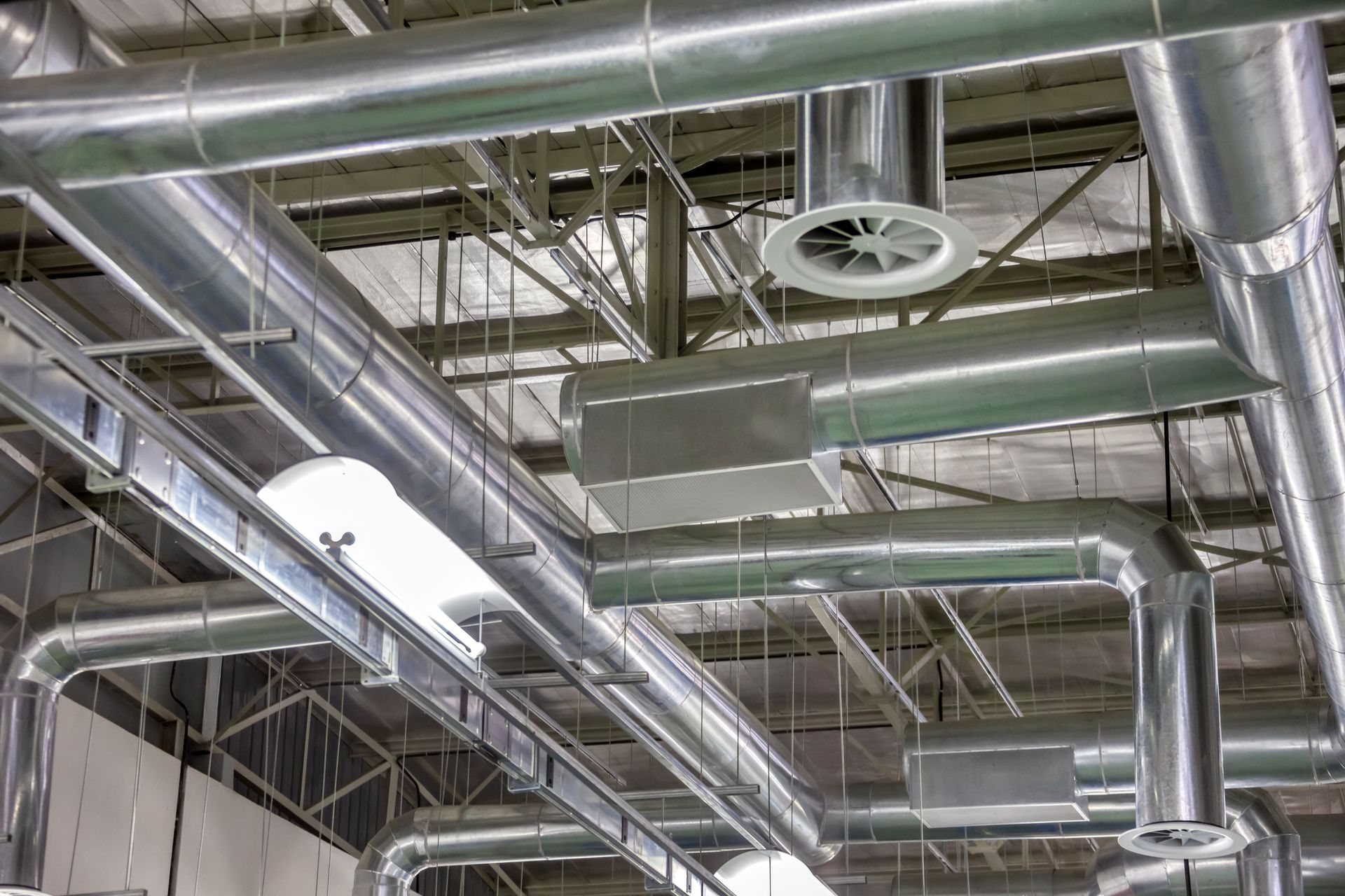 Ceiling of industrial ductwork and ventilation pipes in a large building interior
