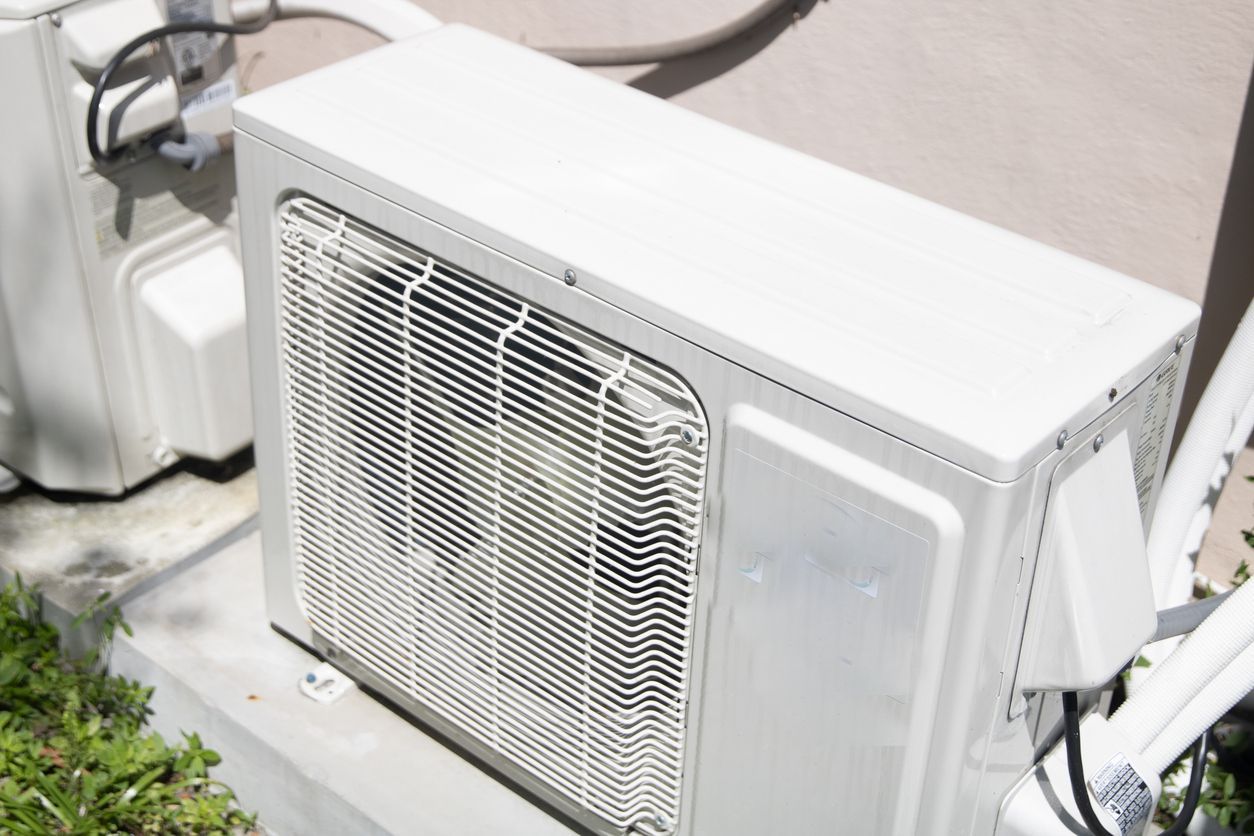 White wall-mounted air conditioner unit with a large vent grille indoors