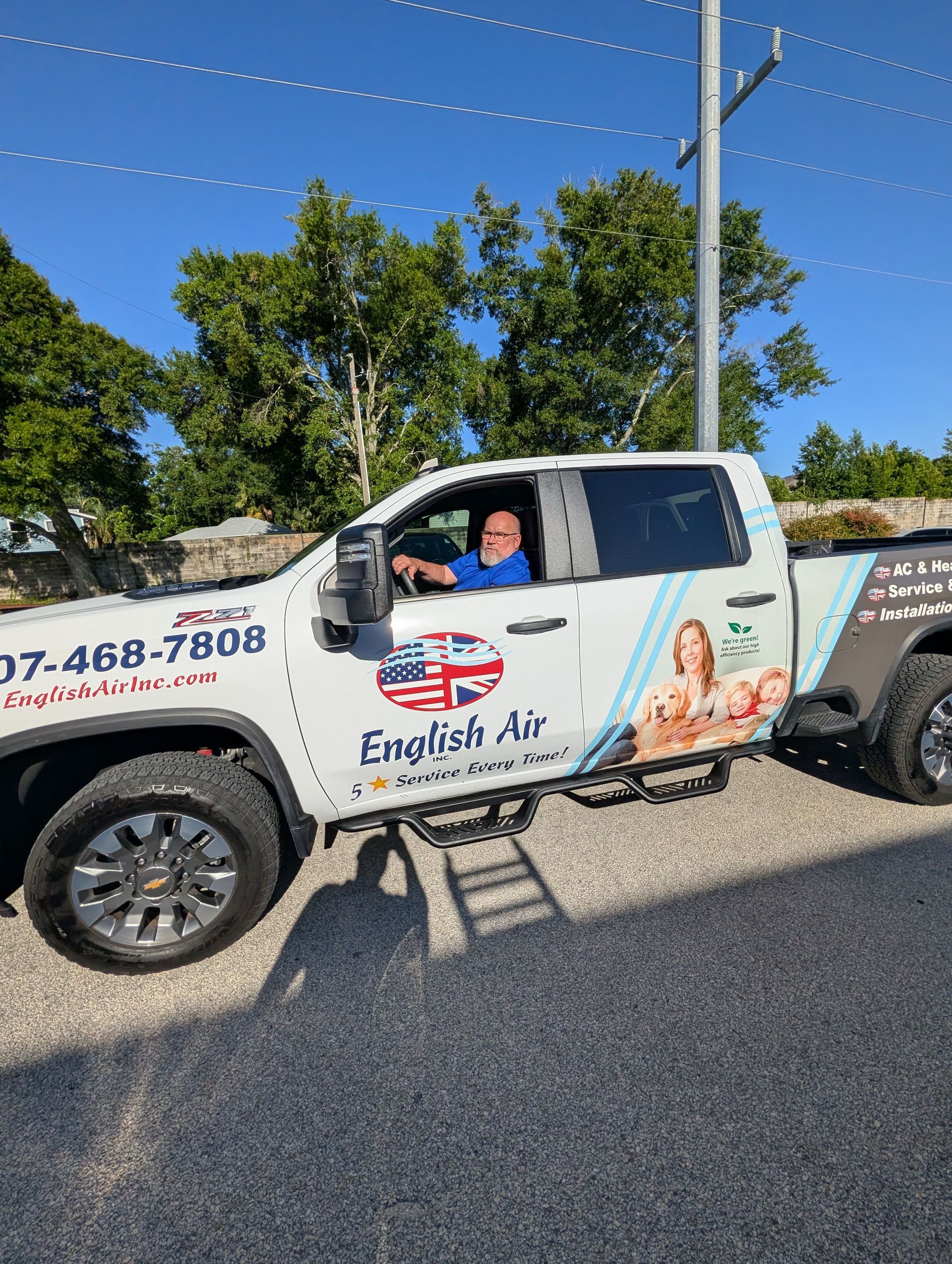 White utility truck with “English Air” branding parked on a road, driver visible in the cab.