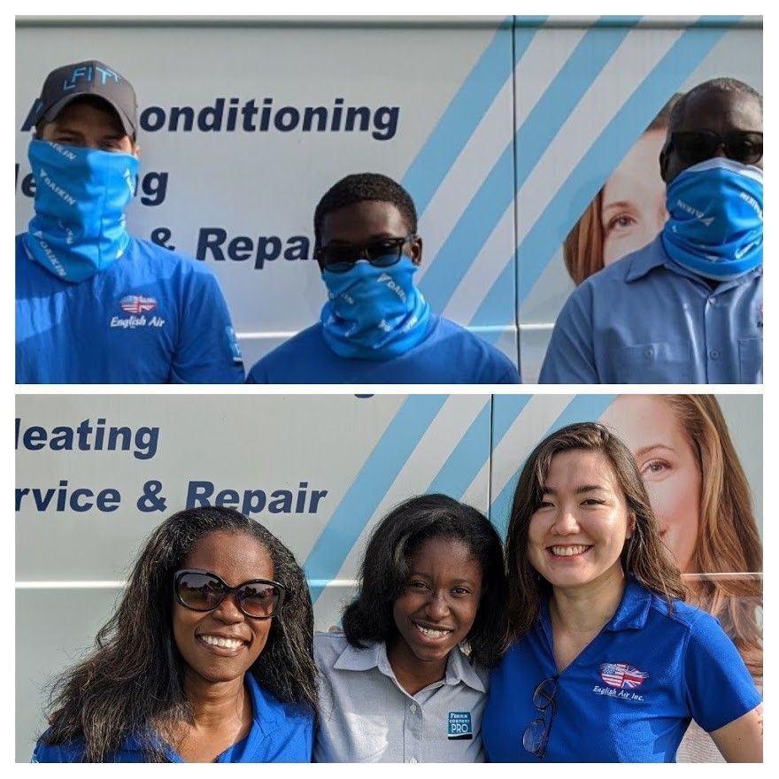 Five HVAC staff in blue uniforms posing in front of a heating and air conditioning service truck