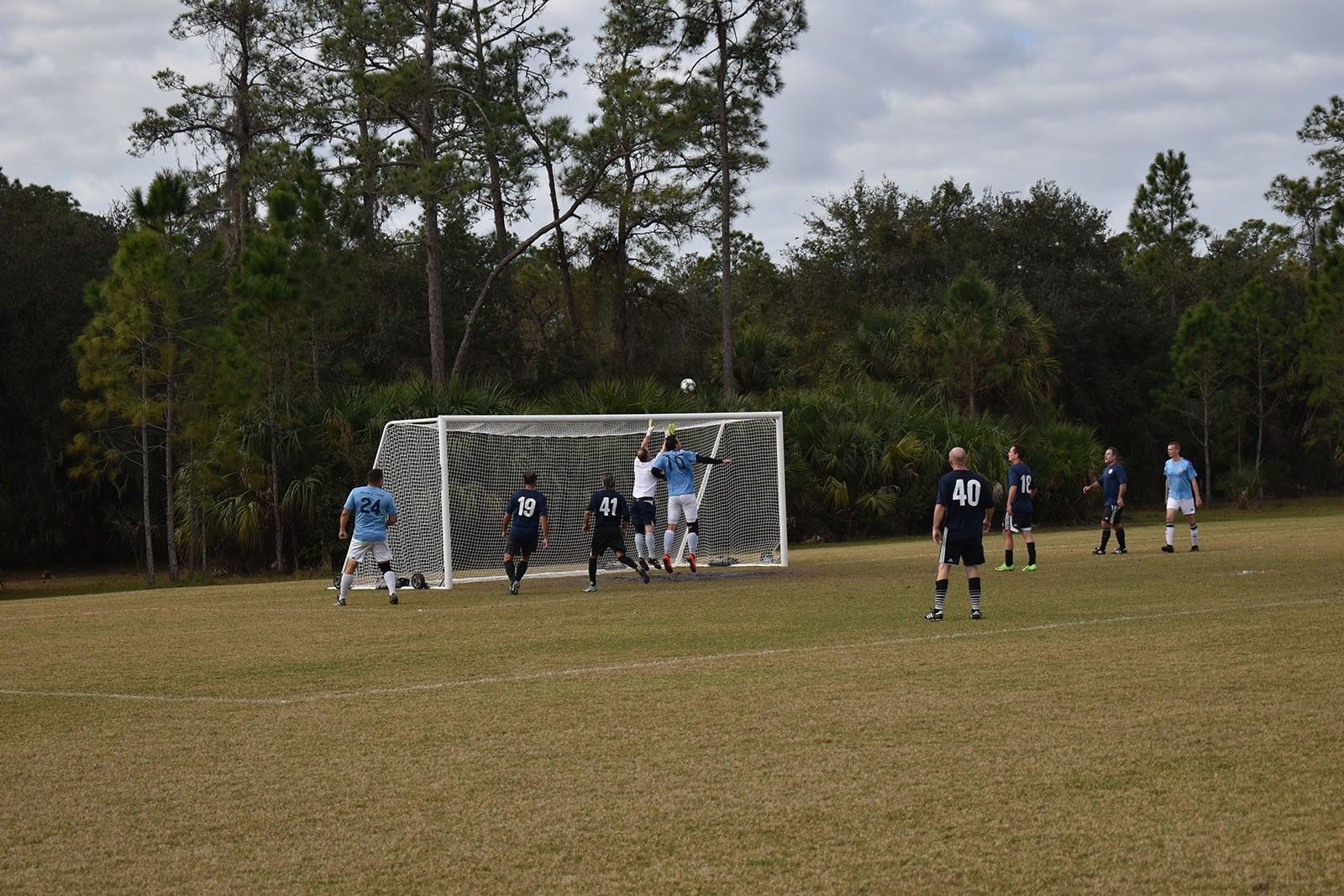 Soccer players crowd the goal during a match on a grassy field