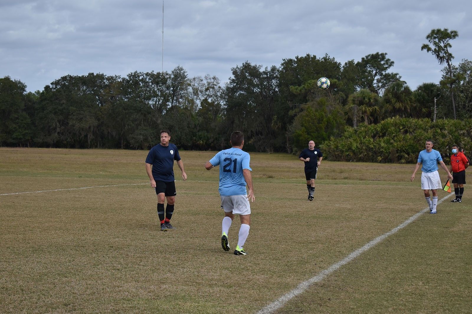 Soccer players in blue and white uniforms on a grassy field during a match