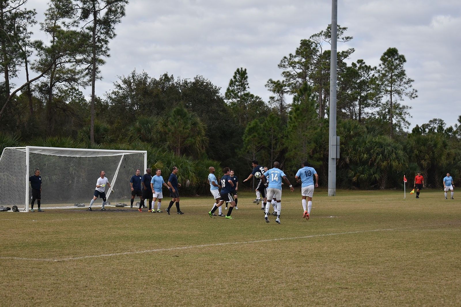 Soccer players gathered near the goal on a grassy field during a match