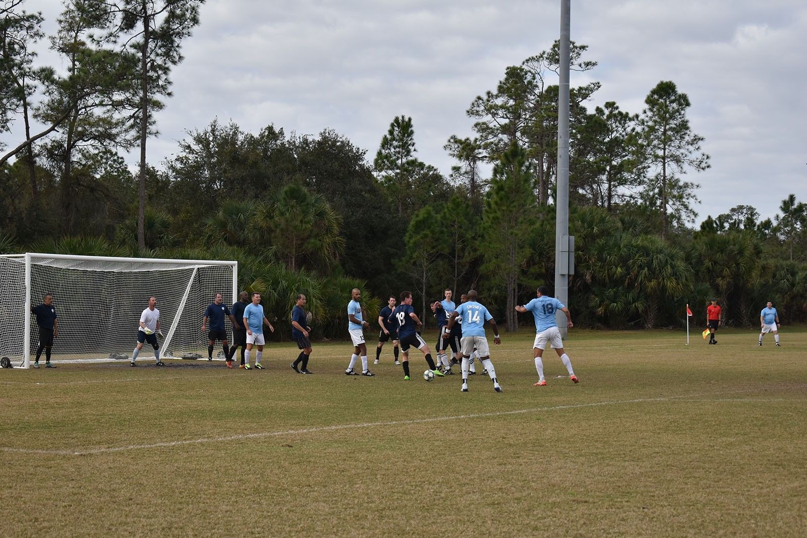 Soccer players cluster near the goal during a match on a grassy field