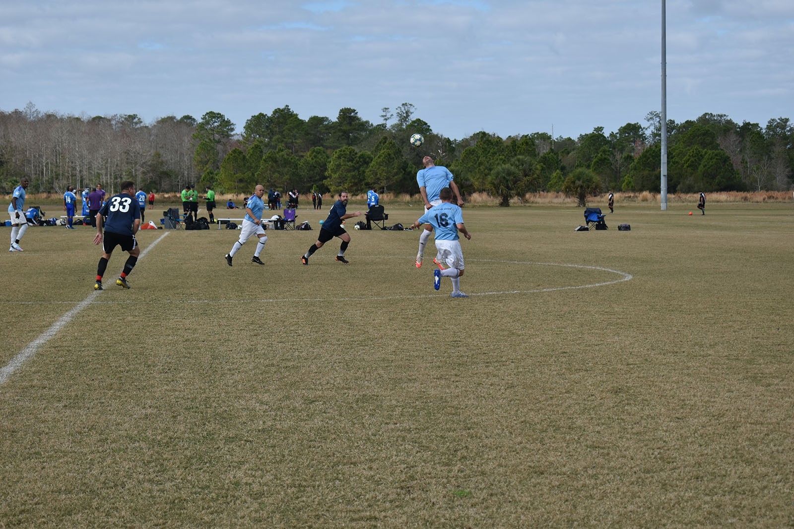 Soccer players in blue and white uniforms on a grassy field during a game